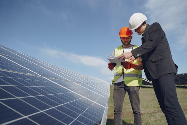 Two men discussing over solar panel project